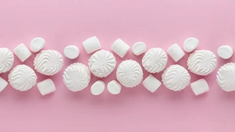 Soft white vanilla zephyr on light pink table. Pastel color. Video with empty sp Stock Footage 254795906