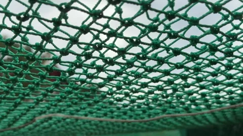 Soft wind passes through a green mesh canopy, forming subtle ripples that glide Vídeo Stock 322514966