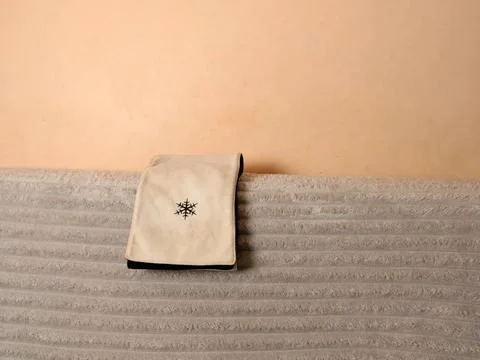 Soft winter hand muff with a snowflake embroidery resting on a light blanket  Stock Photos