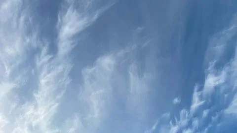 Soft, wispy cirrus clouds in a vast blue sky. Ideal for a serene nature bac.. Stock Photos