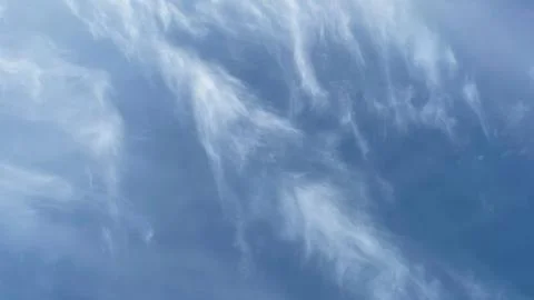 Soft, wispy cirrus clouds in a vast blue sky. Ideal for a serene nature bac.. Stock Photos