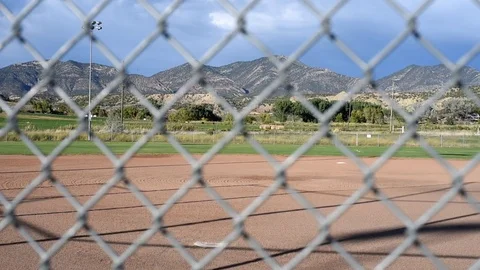 Softball field focus pull from mountains to chain link fence. Stock-Footage 83426092