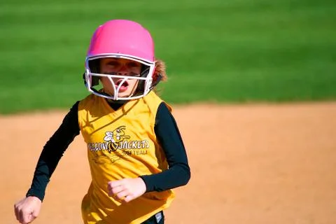 Softball Player Running to Third Base Stockfoto's