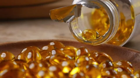 Softgel capsules pouring out of opened glass bottle Vídeo Stock 330924943
