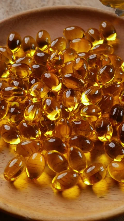 Softgel capsules pouring out of opened glass bottle Vídeos de archivo 330924946