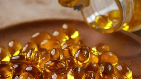 Softgel capsules pouring out of opened glass bottle Vidéo 331056106