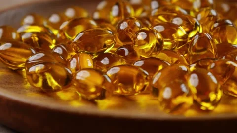Softgel capsules pouring out of opened glass bottle Vidéo 331115402
