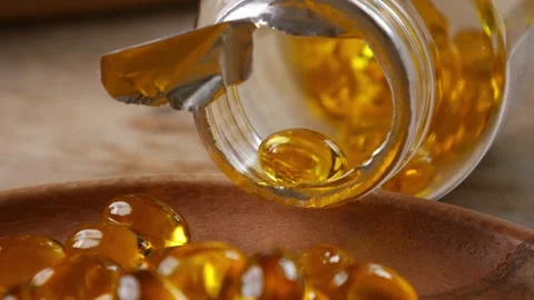Softgel capsules pouring out of opened glass bottle Video stock 331901008