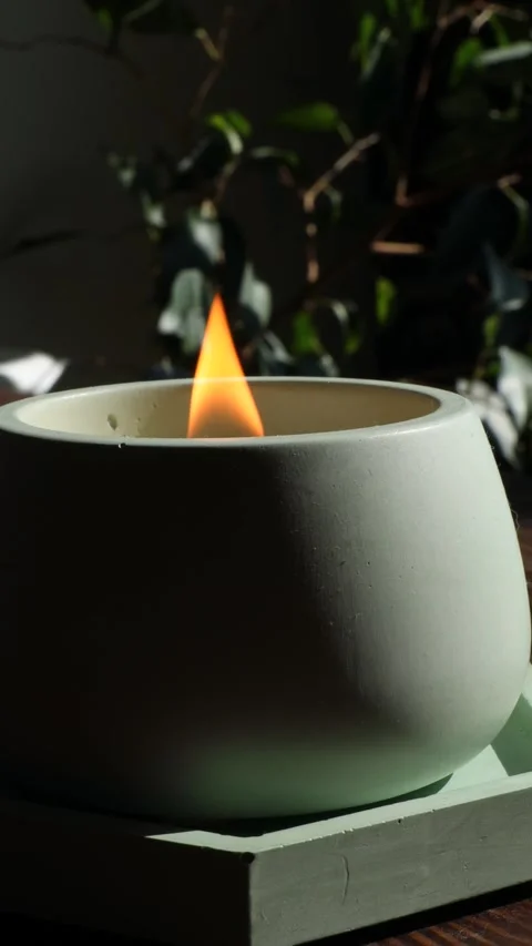 Softly burning candle in pale ceramic holder with warm flame and peaceful Stock Footage 310337660