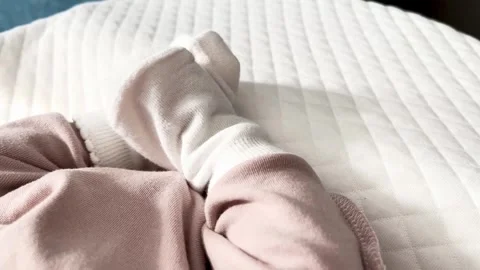 Softly clad infant foot emerges from cozy fabric Stock Footage 321061453