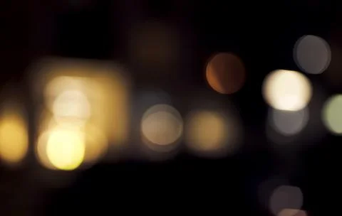 Softly diffused warm lights form abstract glowing shapes against a dark Stock Photos