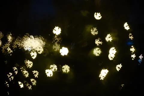 Softly glowing snowflake lights create a magical ambiance in a dark setting.. Stock Photos