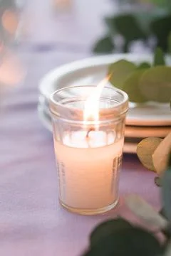 Softly Lit Candle on Elegant Table Setting with Eucalyptus Stock Photos