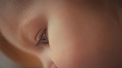 In a softly lit portrait studio a little girls face fills the frame her eye Stock Footage 331866332