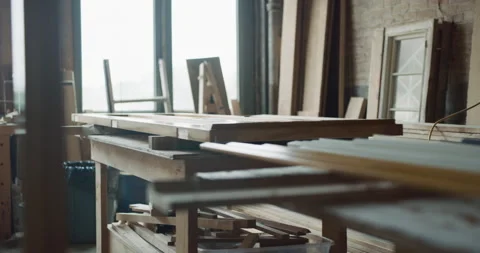 Softly lit wood workshop with door being built on table with saws and tools. Wid Stock Footage 199456655