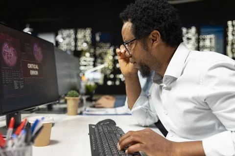 Software developer adjusts glasses, surprised by application errors while coding 스톡 사진