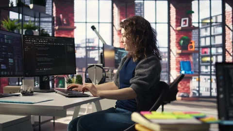 Software developer at agency office coding on her computer, Stock Footage 308671742