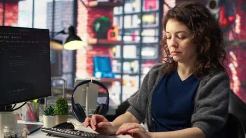 Software developer at agency office coding on her computer, Stock Footage 308672875