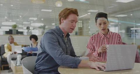 Software developer and UX designer collaborating over laptop, floating chart Stock Footage 308602186