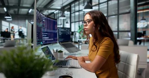Software Developer Calmly Codes Using Cloud-based IDE On Her Desktop Workspac Stock Photos