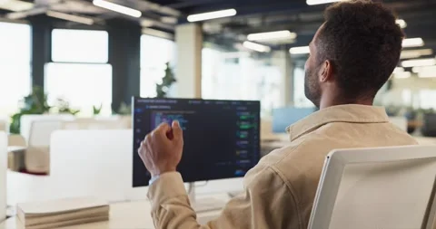 Software developer celebrating coding success at desktop in modern open office Video stock 337548317