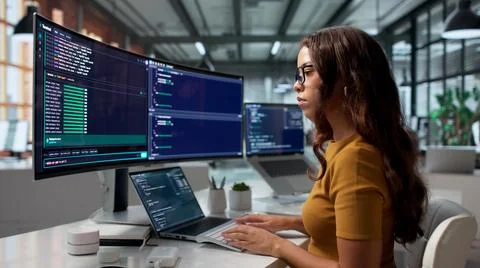 Software Developer Codes Remotely Using Cloud-based IDE On Her Secure Desktop 库存照片