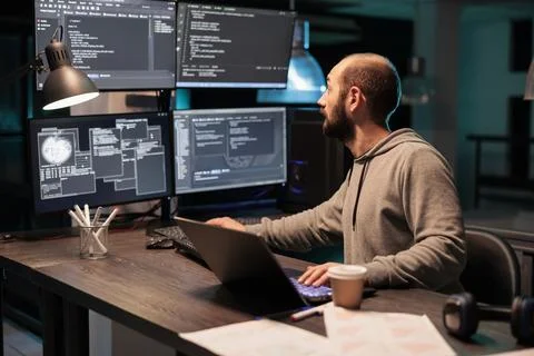 Software developer coding database on multiple monitors 库存照片