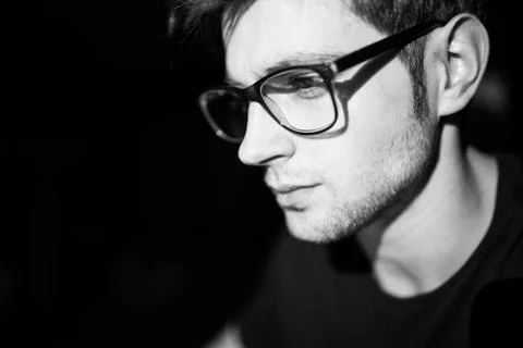 Software developer coding on his laptop  with reflection on his glasses at ni Stock Photos