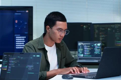 Software Developer Coding with Multiple Screens Fotos Stock
