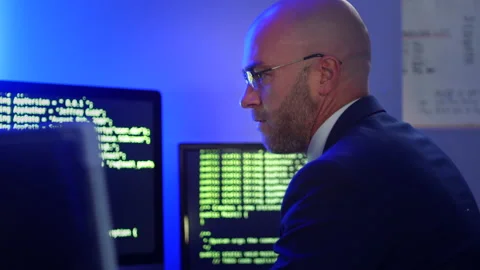 Software developer coding in an office on a computer with multiple screens Stock Footage 161647655