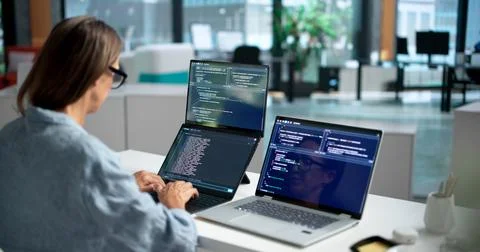 Software Developer Collaborates Coding On Dual Touchscreens In Shared Workspa Foto stock