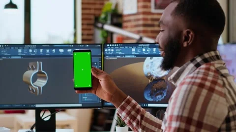Software developer creates a gear prototype on dual monitors next to chroma key Stock Footage 319710928
