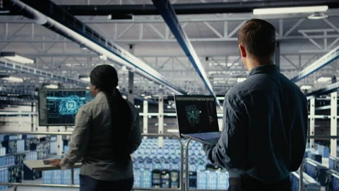 Software developer in data center checks AI dashboard using laptop Stock Footage 314683284