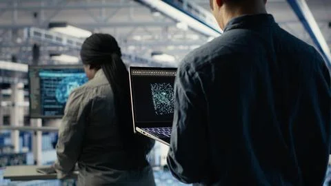 Software developer in data center checks AI dashboard using laptop 写真素材