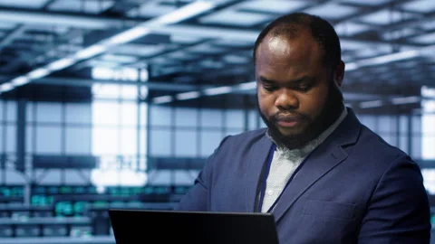 Software developer in data center runs system diagnostic tests on notebook Stock Footage 277643155