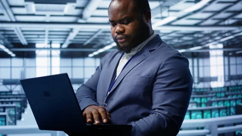 Software developer in data center runs system diagnostic tests on notebook Stock Footage 277645301