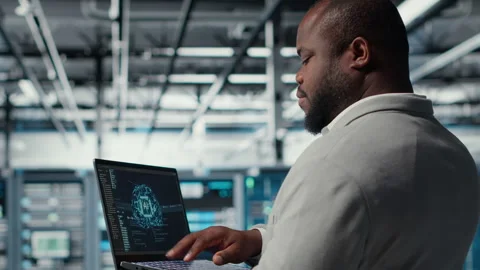 Software developer in data center uses AI technology on laptop Stock Footage 311897370