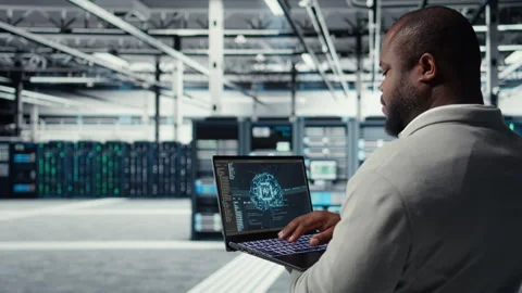 Software developer in data center uses AI technology on laptop Stock Footage 311961353