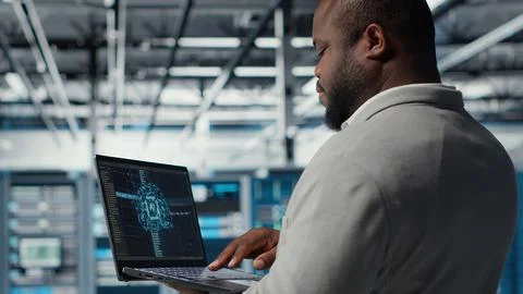 Software developer in data center uses AI technology on laptop 写真素材