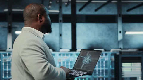 Software developer in data center using artificial intelligence tech on laptop Stock Footage 311897483