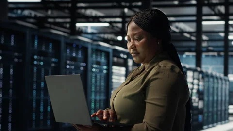 Software developer in data center using laptop to upgrade systems Stock Footage 317126708