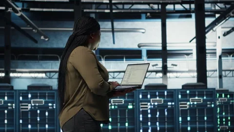 Software developer in data center using laptop to deploy new server architecture Stock Footage 317127016