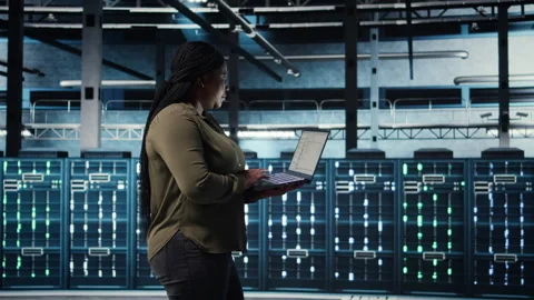 Software developer in data center using laptop to deploy new server architecture Stock Footage 317127087