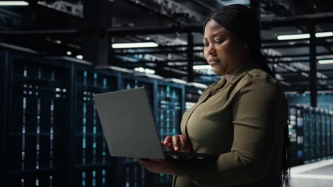 Software developer in data center using laptop to upgrade systems Stock Footage 317201517