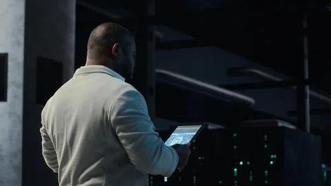 Software developer in data center using tablet, employing machine learning 写真素材