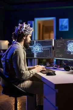 Software developer with EEG headset on writing code Stock Photos