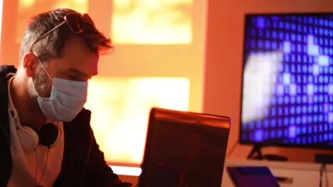 Software Developer With Face Mask Working on Laptop. Male Hacker During Stock Footage 139446637