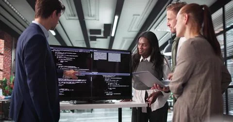 Software Developer Leading Late-Night Meeting With Programmer Team In Office 库存照片