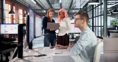 Software Developer Leads Diverse Team Managing Tasks On Digital Kanban Board. Stock Photos