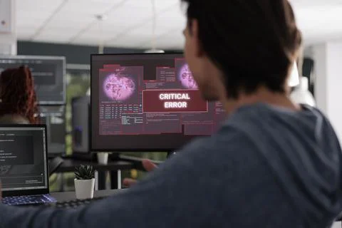 Software developer looking at display writing code encountering hacking alert 스톡 사진